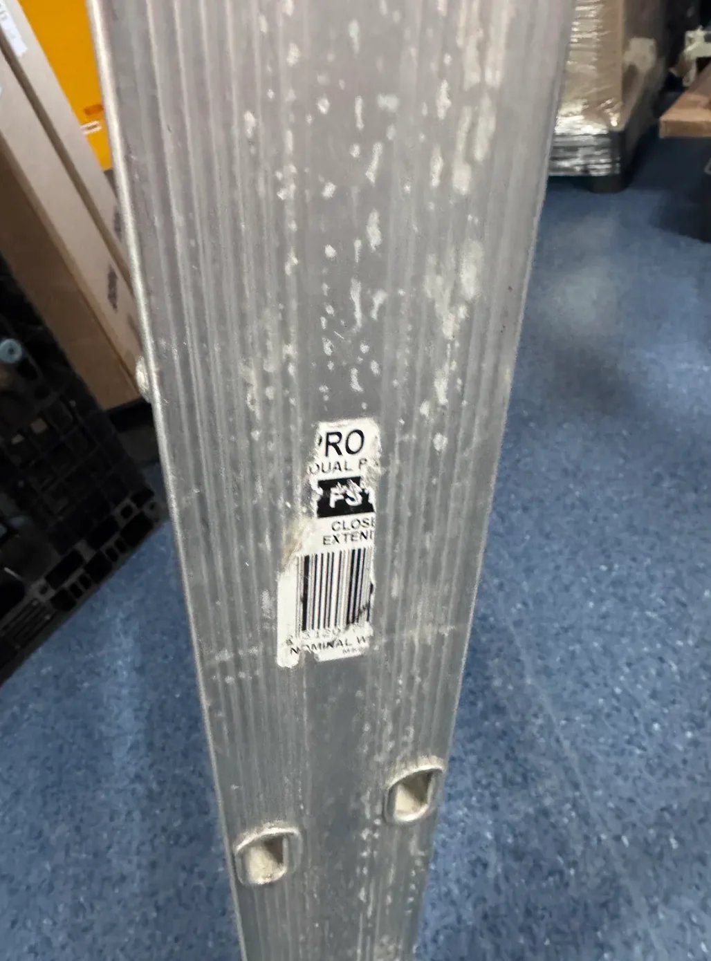Clear plastic roll or sheet with product label and barcode on blue floor