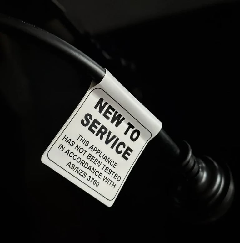 A white service tag attached to a black bicycle frame indicating new to service with testing information